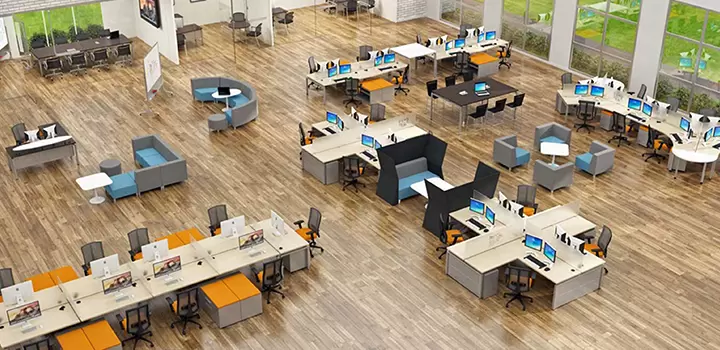 Open-plan office where colleagues stand and stretch beside their desks